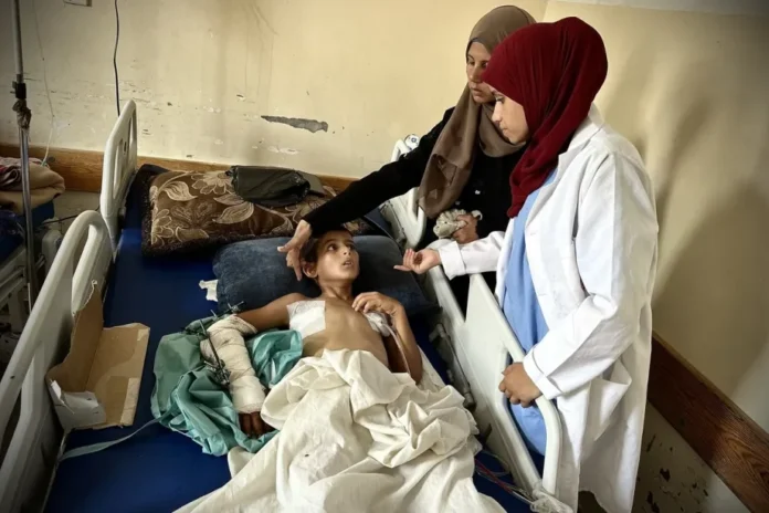 AA-20250814-38827012-38827007-GAZA_MOTHER_SEEKS_TREATMENT_FOR_11YEAROLD_SON_INJURED_AT_AID_CENTER-1-1